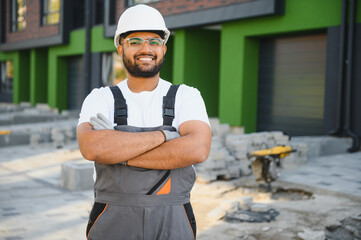 Professional plumber and repairman stands in the background of the cottage. The concept of the job...