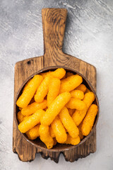 Irresistible Cheese puffs, cheese snacks bursting with bold flavors and a satisfying crunch. grey background. top view