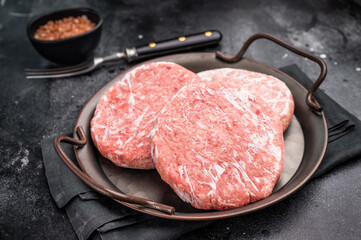 Frozen Meat cutlet, mincemeat of pork and beef for burgers. black background. top view