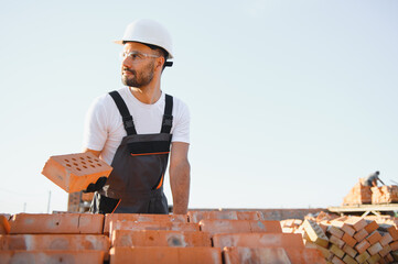 Construction worker in uniform and safety equipment have job on building. Industrial theme
