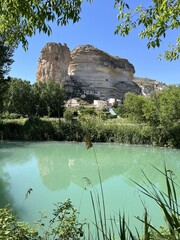 White rocks and blue river Jucar in Alcala del Jucar with cliffside white houses. Charming Spanish village built into the cliffs of a dramatic canyon, Castilla-La Mancha, Spain