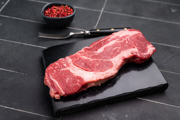 Raw Chuck eye roll steak, fresh prime beef meat. black background. top view