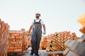 Installing brick wall. Indian Construction worker in uniform and safety equipment have job on...