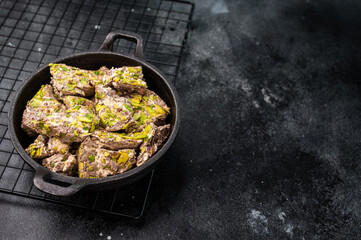 Oriental Halva with pistachio in a skillet. Natural vegan sweets. black background. top view.