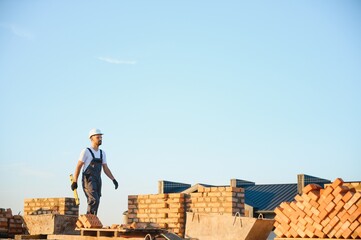 Construction worker in uniform and safety equipment have job on building