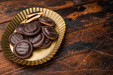Steel plate with  Jaffa Cookies covered with chocolate and filled with jam. Wooden background. top view