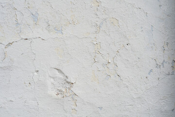 Textura de pared blanca con pintura descascarada y grietas © Manuela