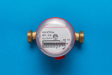 Close-Up of Water Meter with Brass Fittings on Blue Background for Utility and Energy Concepts
