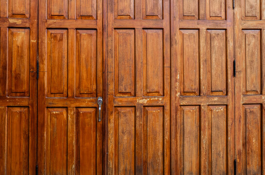 Puerta de madera antigua con paneles y herrajes met&aacute;licos