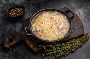Chicken noodle soup with Vermicelli and meat in a bowl. black background. top view