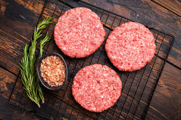 Raw meat patties, cutlets, chopped meat for burgers. wooden background. top view