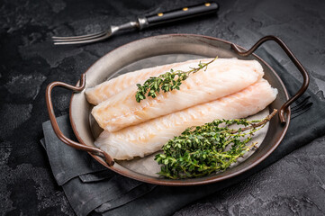 Raw Loin cod fish fillets ready for cooking whitefish in stell tray. black background. top view