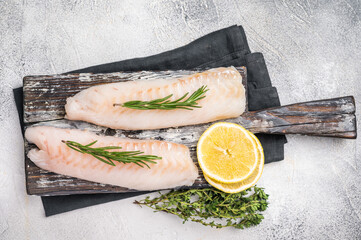 Raw cod Loin, white fish fillets without skin on wooden board. white background. top view