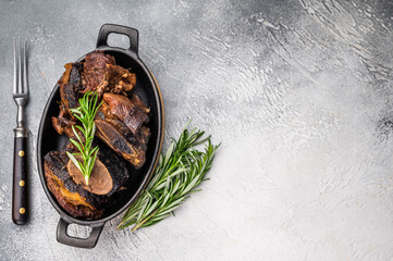 Grilled beef short ribs glistening under natural Beef short ribs slow-cooked to perfection, served on a stylish plate with vibrant sides, showcasing a delicious and hearty meal. 