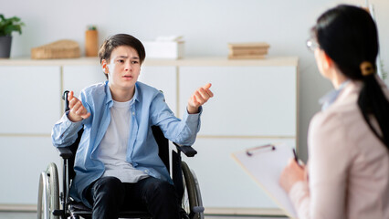 Professional psychological help for disabled teens. unhappy handicapped adolescent talking to...
