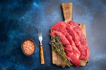Beautifully sliced raw buffalo meat on a rustic platter, showcasing its appealing color and...