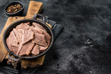 Cooked Boiled lamb meat in a skillet. black background. top view