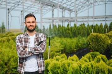 portrait of a young gardener on a plantation of bush seedlings.