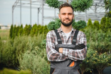 Fototapeta premium portrait of a young gardener on a plantation of bush seedlings.