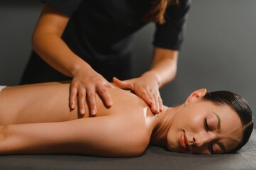 Masseur doing massage on woman body in the spa salon. Beauty treatment concept