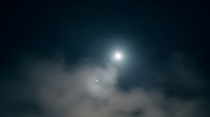 Obraz premium Bright star shining above soft nebulous clouds in a dark night sky