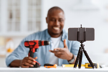 Carpenter blogger recording video review of instruments on phone, selective focus, closeup. Happy...