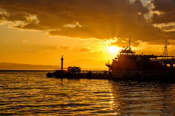 Erdek, Turkey - February 8, 2024 : Erdek Town harbor with ships at sunset