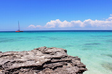 sailboat and rocky shore in the Caribbean