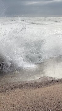 Huge waves crashing over Breakwater during winter storm Atlantic waves washing the lighthouse on Praia da Aguda sandy beach at Aguda settlement near Porto, Portugal. 4K vertical video.