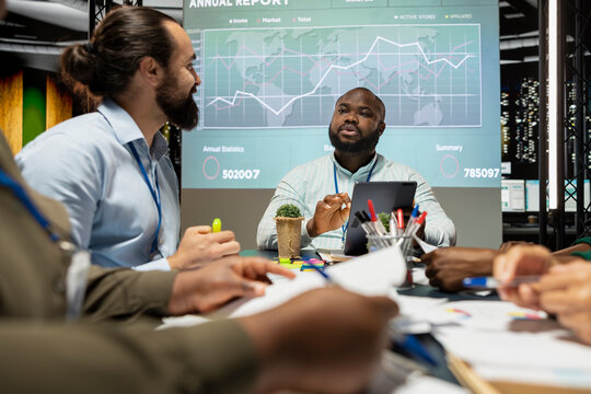 Team of general managers attending a briefing meeting late at night to verify updates on regulatory changes or industry standards. Business professionals reviewing all data analysis.