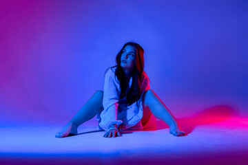 Model poses creatively against colorful backdrop during a fashion photoshoot in a studio setting at...