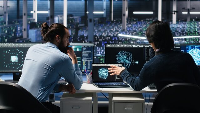 Server room system administrators using AI to review infrastructure diagnostics. IT professionals in data center analyzing performance data using artificial intelligence technology, camera A