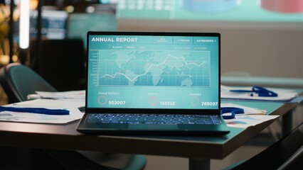 Close up of laptop running data insights in empty dark office late at night, forecasting financial...