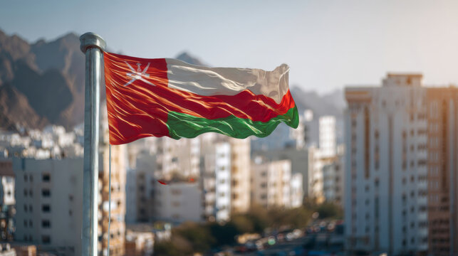 Flag of Oman waving proudly in the wind against the backdrop of urban buildings on Independence Day - Powered by Adobe