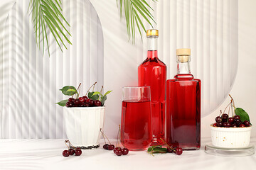 Homemade strong cherry cider in bottles and glasses on elegant background, still life with...