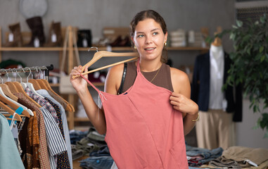 Woman shopping in clothing department, buying crop top. Off line clothing store from leading...