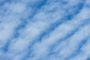 blue sky with autumn clouds and a plane
