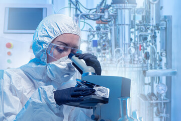 Woman lab technician using microscope. Chemist at work. Scientist near bioreactor. Lab technician focused on work. Microbiologist scientist in protective clothing. Woman biologist scientist