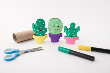 Handmade paper cactus project with tools on table, perfect for craft supply stores, DIY kits for kids, educational product packaging, and creative workshops focused on fun and learning © Elena