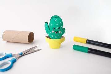 Cute cardboard cactus trio in painted tube pots with drawn faces and spines, perfect for kids magazines, craft blogs, product packaging, and creative workshop visuals © Elena