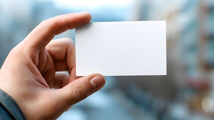 Obraz premium Blank White Business Card Held by Hand for Professional Use