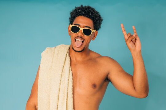 young man with sunglasses in swimming trunks in summer isolated on background
