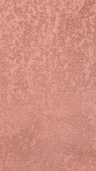 Textured surface with a warm pink hue showcasing fine details and subtle variations in color and pattern