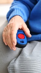 Elderly person holding a medical alert device