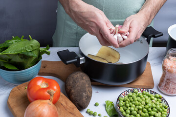 Taking garlic among other vegetables for cooking.