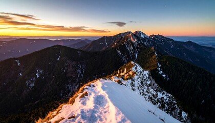 A breathtaking panorama of snow-capped mountain peaks at sunrise, showcasing a vast landscape of dark forests and vibrant colors.