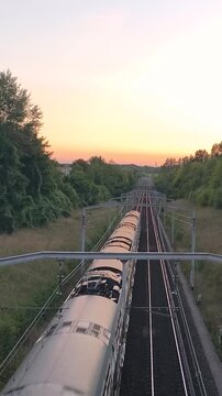 Vertical 4K sunset shot of RER A train passing through Paris suburbs.