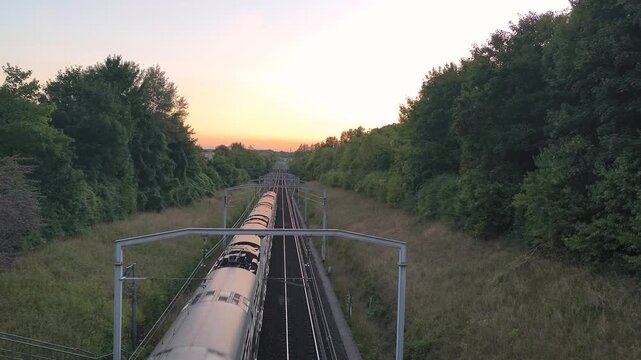4K sunset shot of RER A train crossing Paris suburbs railway.