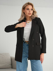 A Stylish Female Model Showcasing a Chic Black Blazer Paired with Casual Denim, Capturing Modern...