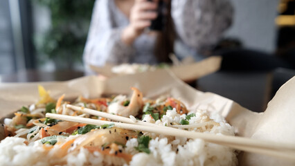 Close-up of Caucasian woman eating pan-Asian cuisine